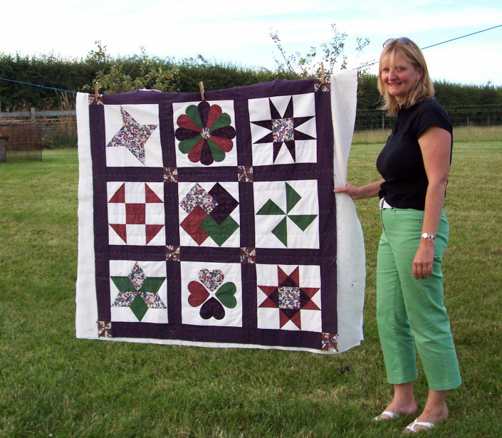 Barbara and her hand-stitched sampler quilt top which she completed on the 10 week evening course.  It is now basted and ready for quilting.
